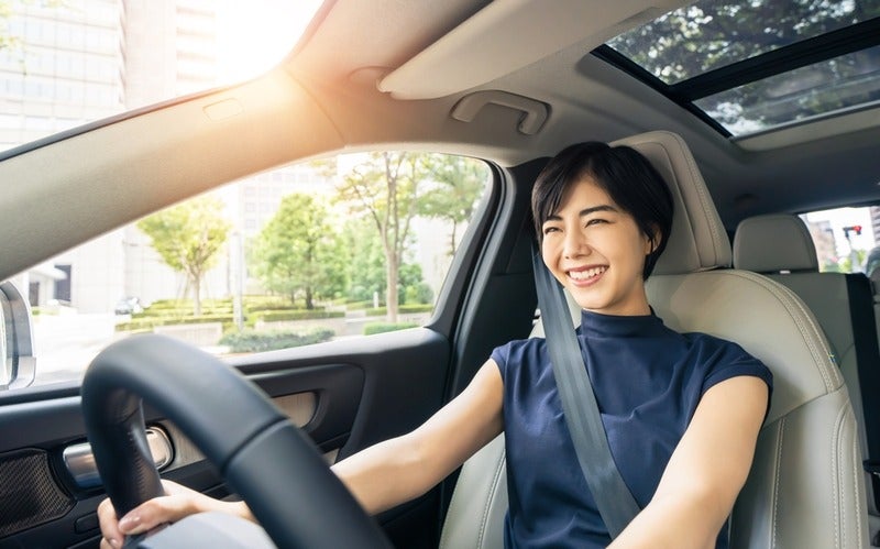 A person is seated in the driver’s seat wearing a seatbelt